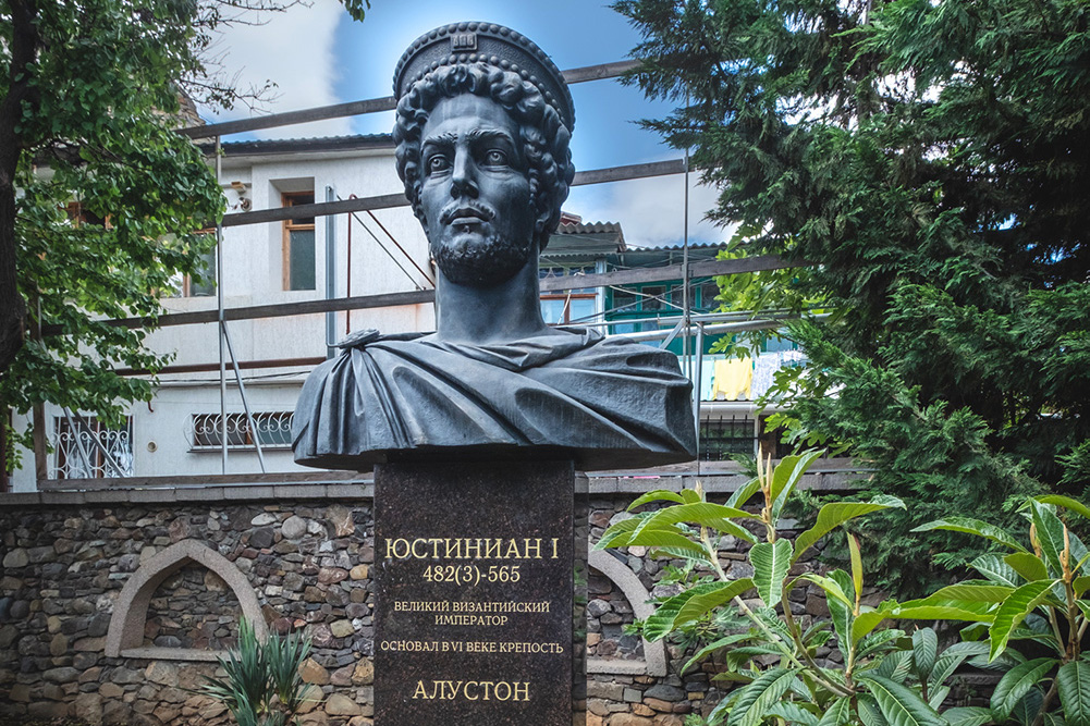 У входа на экспозицию воссозданной крепости Алустон установлен памятник её основателю - византийскому императору Юстиниану I